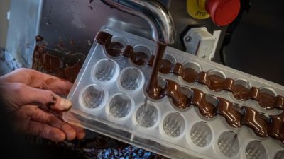 Remplissage des moules à chocolat pendant le stage chez un chocolatier dans un atelier de chocolaterie vers le Pays Basque