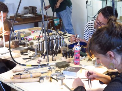Stagiaires pendant la formation bijouterie option sertissage avec un bijoutier à Lourdes