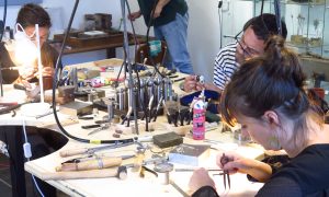 Stagiaires pendant la formation bijouterie option sertissage avec un bijoutier à Lourdes