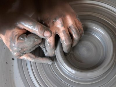 Mains d'un stagiaire façonnant l'argile sur un tour de potier lors d'une formation en tournage céramique à Montpellier