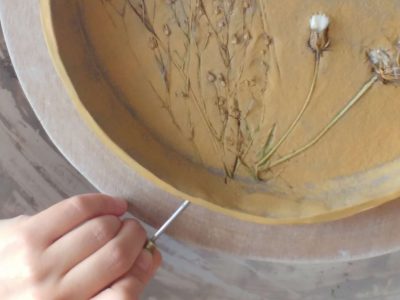 Main d'une céramiste sur un plateau en argile, réalisé lors d'une formation en céramique en Charente