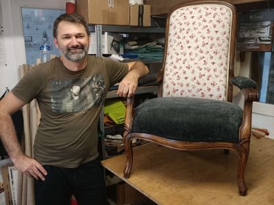 Stagiaire posant à côté d’un fauteuil restauré lors d’une formation tapissier à Montpellier