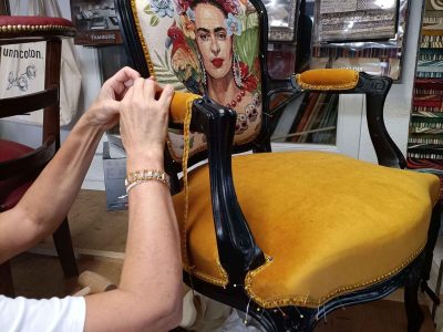 Apprenant travaillant sur la finition d'un fauteuil rénové pendant une formation tapissier à Montpellier