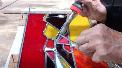 Soudure pendant le stage de vitrail traditionnel avec un vitrailliste