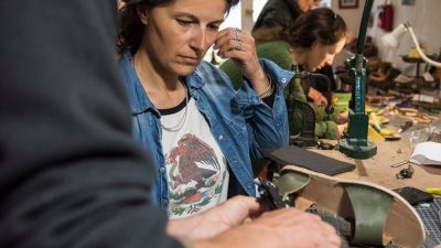 Stagiaire qui apprend le métier de bottier au côté de son professeur