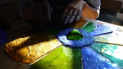 Réalisation en cours d'un vitrail mexicain et écologique par un stagiaire pendant un stage