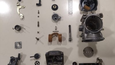 Pièces de carburateur moto pendant le démontage lors d'un atelier