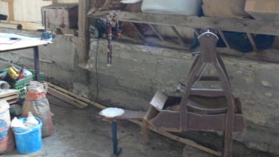 Cardeuse à crin dans l'atelier au cours du stage en tapisserie d'ameublement pour coudre un coussin de fauteuil Bergère