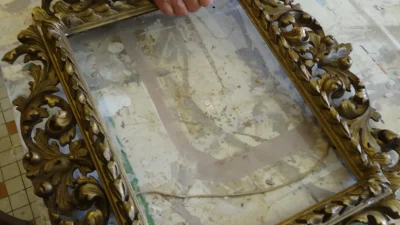 Geste de restauration d'un cadre pendant l'atelier de rénovation et restauration de meubles vers Bordeaux en Gironde