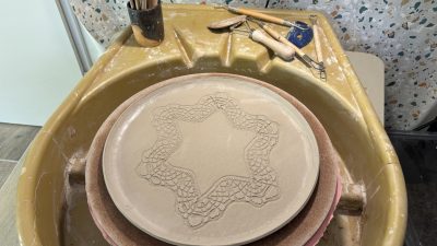 Réalisation d'un plat de service avec un flocon de neige pour Noël pendant le stage de céramique et poterie