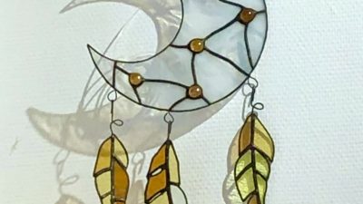 Vitrail en forme de lune blanche avec des plumes pendant l'atelier de vitrailliste à Tarbes