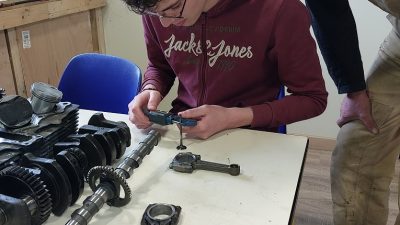 Stagiaire en cours d'apprentissage avec Samuel pendant le stage sur un moteur de moto