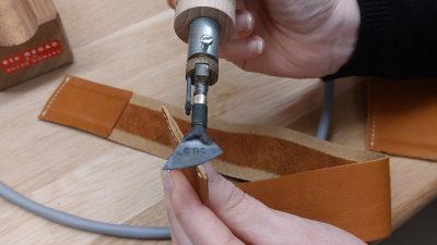 Lissage de tranche pendant l'atelier de maroquinerie à Cholet