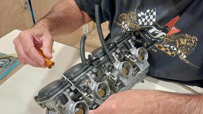 Stagiaire qui démonte et découvre un carburateur moto pendant un stage